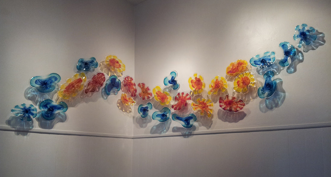 Colored glass sculptures hang on a wall