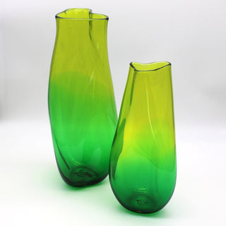 Two green vases sit in front of a white background